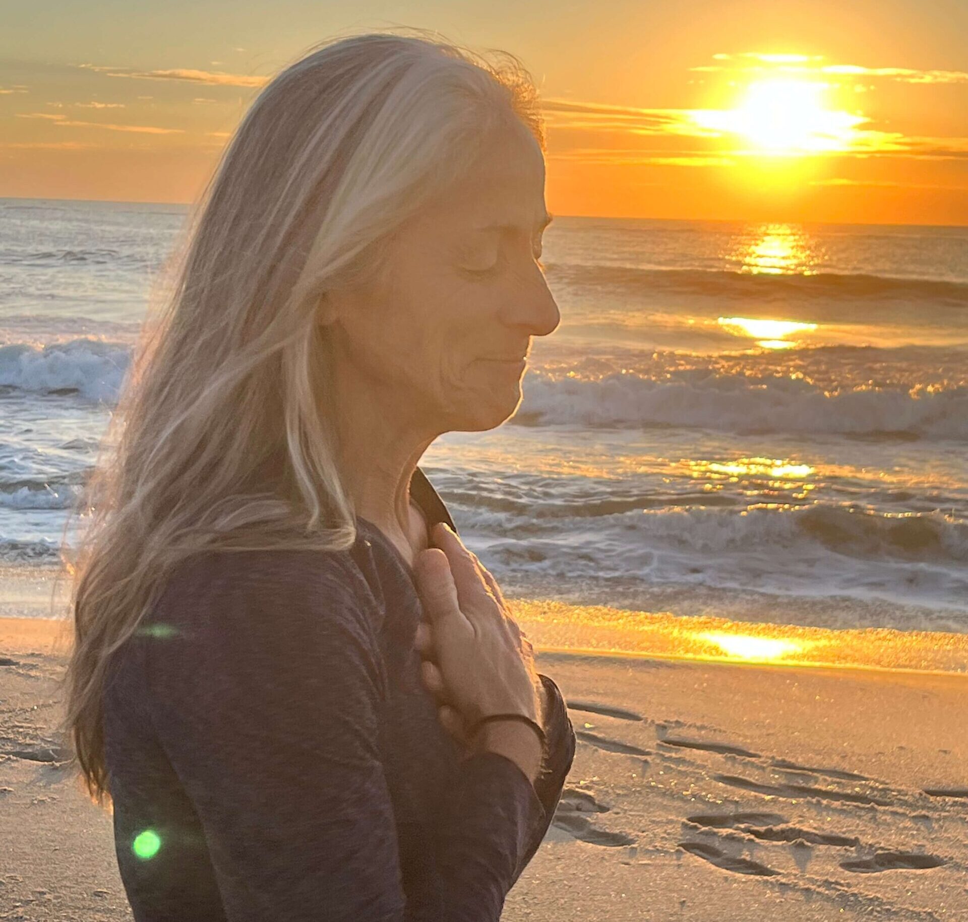woman on the beach with sunset in the background